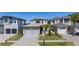 A modern two-story home boasts a manicured lawn, stone accents, and attached two-car garage at 15847 Vetta Dr, Bella Collina, FL 34756
