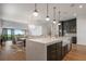 Open-concept kitchen with an island, stainless steel appliances, and a view of the dining and living area at 15847 Vetta Dr, Bella Collina, FL 34756