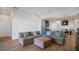 Spacious living room with a plush sofa and hardwood floors, leading to an open kitchen and dining area at 15847 Vetta Dr, Bella Collina, FL 34756
