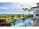 Backyard pool with a water feature, surrounded by landscaping and palm trees on a sunny day at 15847 Vetta Dr, Bella Collina, FL 34756