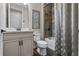 Modern bathroom with a gray vanity, sleek countertop, and tiled shower-tub behind a textured shower curtain at 16144 Parkwyn St, Winter Garden, FL 34787