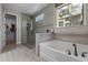 Elegant bathroom features a glass shower, soaking tub, and modern tile work, creating a spa-like retreat at 16144 Parkwyn St, Winter Garden, FL 34787