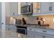 Kitchen featuring gray cabinets, stainless steel appliances, and granite countertops at 16144 Parkwyn St, Winter Garden, FL 34787