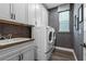 Well-organized laundry room with modern appliances, ample cabinet space, and a convenient utility sink at 16144 Parkwyn St, Winter Garden, FL 34787