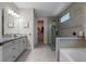 Spacious and bright main bathroom with double vanities, a walk-in shower and a soaking tub at 16144 Parkwyn St, Winter Garden, FL 34787