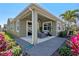 Covered outdoor patio with seating, surrounded by landscaped gardens and a tropical palm at 16144 Parkwyn St, Winter Garden, FL 34787