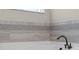 A detail shot highlights the tub's bronze fixtures and neutral-toned, decorative tile surround at 16144 Parkwyn St, Winter Garden, FL 34787