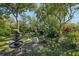 Serene backyard garden featuring a stone fountain, mature trees, and lush landscaping at 215 Forrest Dr, Sanford, FL 32773