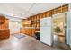 Rustic garage showcasing wooden cabinets, concrete floors, fridge and a view into an adjacent room at 215 Forrest Dr, Sanford, FL 32773