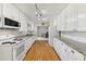 Bright kitchen features white cabinets, wood floors, granite countertops, and modern appliances at 215 Forrest Dr, Sanford, FL 32773