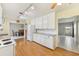 Kitchen boasts white cabinets, wood floors, granite countertops, and stainless-steel refrigerator at 215 Forrest Dr, Sanford, FL 32773