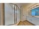 Bathroom with shower featuring glass doors, updated vanity with modern faucet, and wood flooring at 2156 Fish Eagle St, Clermont, FL 34714