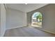 Bedroom featuring neutral carpet, large arched window, and a closet with doors at 2156 Fish Eagle St, Clermont, FL 34714