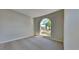 Bedroom featuring neutral carpet, white trim, and a large arched window at 2156 Fish Eagle St, Clermont, FL 34714