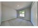 Bedroom featuring neutral carpet, white trim, and a window with backyard view at 2156 Fish Eagle St, Clermont, FL 34714
