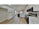 Modern kitchen with stainless steel appliances, white cabinets, and wood-look floors at 2156 Fish Eagle St, Clermont, FL 34714