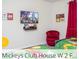 Whimsical Mickey Mouse-themed bedroom with a red accent chair and a TV at 218 Ocean Course Ave, Davenport, FL 33896