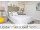 Upstairs Primary bedroom with a stylish wooden headboard and lamps at 218 Ocean Course Ave, Davenport, FL 33896