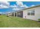 Backyard with a lawn, white exterior wall, and a screened-in patio at 2312 Datura Loop, St Cloud, FL 34772