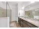 Bathroom featuring double sinks, granite countertops, and a glass-enclosed shower at 2312 Datura Loop, St Cloud, FL 34772