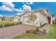 Charming villa featuring a brick driveway and attached garage with a beautifully landscaped front yard at 2312 Datura Loop, St Cloud, FL 34772