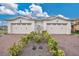 Charming villa with two-car garage and red brick drive, complemented by lush landscaping at 2312 Datura Loop, St Cloud, FL 34772