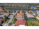 Aerial view of homes near lake and bridge, with lush landscaping and a green location pin on one of the roofs at 2541 Shoal Bass Way, Kissimmee, FL 34746