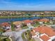 Aerial view showcases homes with tile roofs, landscaping, and community lake views at 2541 Shoal Bass Way, Kissimmee, FL 34746