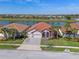 Aerial view of a beautiful home with a tile roof, well-manicured lawn, and lush landscaping at 2541 Shoal Bass Way, Kissimmee, FL 34746