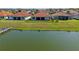 Stunning backyard overlooking the canal with a lush green lawn and terra cotta roof on a sunny day at 2541 Shoal Bass Way, Kissimmee, FL 34746