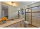 Stylish bathroom featuring granite countertops, decorative mirror, and a glass-enclosed shower at 2541 Shoal Bass Way, Kissimmee, FL 34746