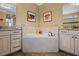 Serene bathroom showcasing a soaking tub and separate vanities at 2541 Shoal Bass Way, Kissimmee, FL 34746