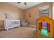 Charming Bedroom with a crib, playful decor, a comfortable armchair, and a fun playhouse at 2541 Shoal Bass Way, Kissimmee, FL 34746