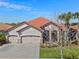 Beautiful home featuring a three-car garage, tile roof, stone accents, and front lawn at 2541 Shoal Bass Way, Kissimmee, FL 34746
