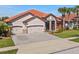 Beautiful single-story home featuring a terra cotta roof, three-car garage, and lush landscaping at 2541 Shoal Bass Way, Kissimmee, FL 34746