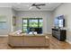 Bright living room with wood floors, a large sectional sofa, and expansive sliding glass doors to the backyard at 2541 Shoal Bass Way, Kissimmee, FL 34746