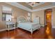 Comfortable main bedroom with hardwood floors and white furniture, leading to a bathroom at 2541 Shoal Bass Way, Kissimmee, FL 34746