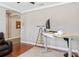 Stylish home office with an adjustable desk, a monitor, and warm wood flooring at 2541 Shoal Bass Way, Kissimmee, FL 34746