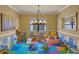Spacious playroom with soft tile flooring, a chandelier, and lots of toys and play equipment at 2541 Shoal Bass Way, Kissimmee, FL 34746