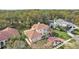 Aerial view of estate home showcasing lush landscaping, paver driveway, mature trees and tile roof at 2747 Kissimmee Bay Cir, Kissimmee, FL 34744