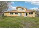 Expansive backyard with lush green grass and a two-story yellow home at 2747 Kissimmee Bay Cir, Kissimmee, FL 34744