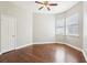Empty bedroom with hardwood flooring, a ceiling fan, and two windows allowing natural light to illuminate the space at 2747 Kissimmee Bay Cir, Kissimmee, FL 34744