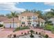 Beautiful two-story home featuring a Spanish tile roof, lush landscaping, and a circular driveway at 2747 Kissimmee Bay Cir, Kissimmee, FL 34744