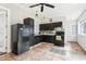 Compact kitchen with black appliances, dark cabinets, tiled backsplash and neutral-toned tile flooring at 2747 Kissimmee Bay Cir, Kissimmee, FL 34744
