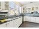 Kitchen with white cabinets, dark countertops, and a window over the sink at 2747 Kissimmee Bay Cir, Kissimmee, FL 34744