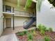 Condo building featuring landscaped grounds, exterior staircase, and second-level balcony at 3242 S Semoran Blvd # 21, Orlando, FL 32822