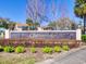 Wimbledon Condominium Community entrance sign with manicured landscaping under a blue sky at 3242 S Semoran Blvd # 21, Orlando, FL 32822