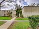 Well-maintained condo exterior with lush landscaping and walkway at 3242 S Semoran Blvd # 21, Orlando, FL 32822