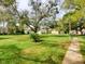 Grassy common area with walking path shows mature trees and updated landscaping at 3242 S Semoran Blvd # 21, Orlando, FL 32822