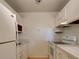 A compact kitchen featuring white appliances and cabinetry needing remodel at 3242 S Semoran Blvd # 21, Orlando, FL 32822